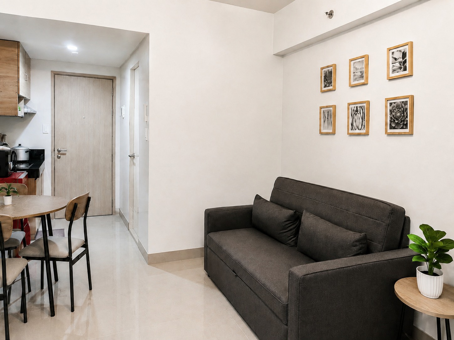 Moon Haven living area with a dark sofa, round dining table, and kitchenette beyond